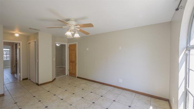 unfurnished room featuring visible vents, baseboards, and ceiling fan