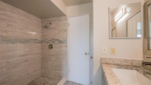 bathroom featuring a tile shower and vanity