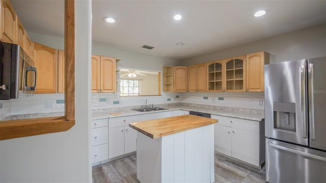 kitchen with tasteful backsplash, visible vents, a sink, stainless steel appliances, and wood counters
