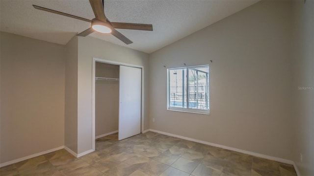 unfurnished bedroom with a closet, ceiling fan, vaulted ceiling, and a textured ceiling
