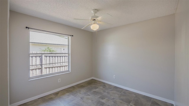 unfurnished room with a textured ceiling, baseboards, and a ceiling fan