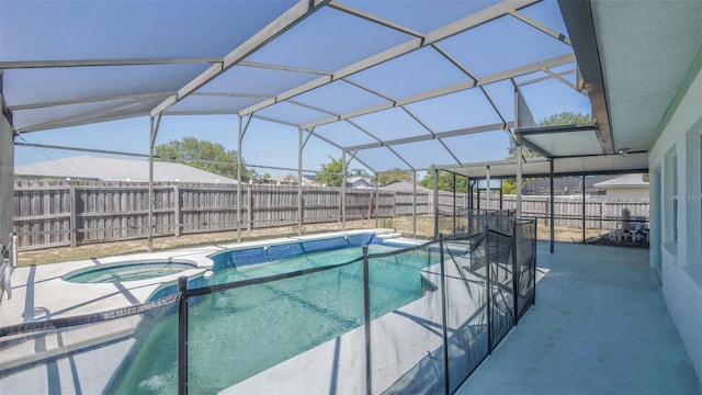 view of pool with a fenced backyard, a pool with connected hot tub, a patio area, and glass enclosure