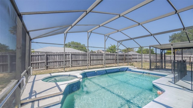 view of swimming pool featuring a fenced backyard, a pool with connected hot tub, a patio area, and glass enclosure