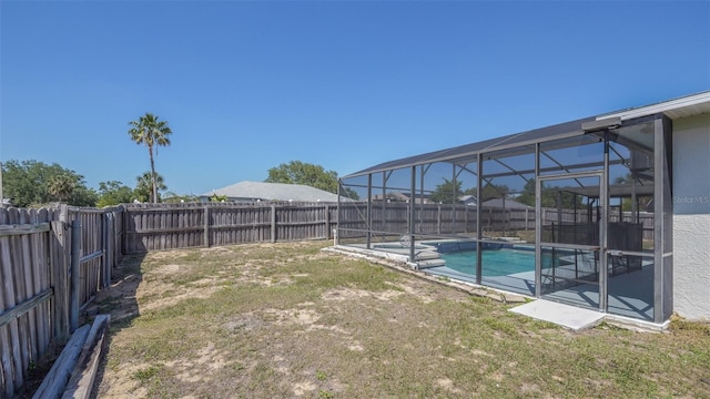view of yard with a fenced backyard, a fenced in pool, and a lanai