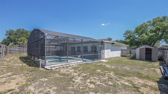 rear view of house featuring a fenced in pool, an outdoor structure, a fenced backyard, glass enclosure, and a storage unit