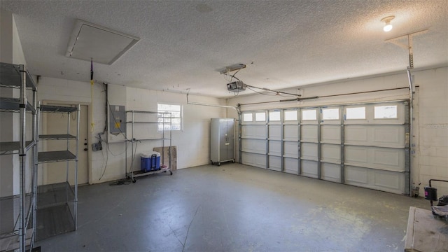 garage with concrete block wall, a garage door opener, and electric panel