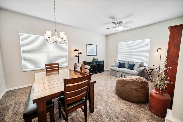 carpeted dining room with visible vents, baseboards, and ceiling fan with notable chandelier