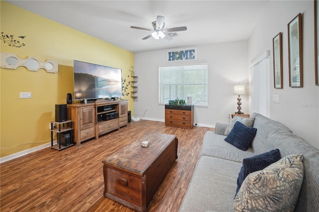 living room featuring baseboards, ceiling fan, and wood finished floors