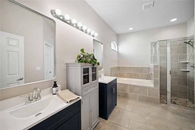 bathroom with a sink, tile patterned flooring, a shower stall, and visible vents