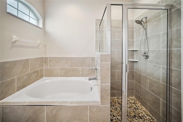 bathroom with a shower stall and a bath