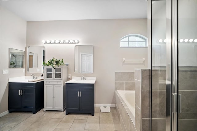 bathroom with baseboards, a sink, tile patterned flooring, and two vanities
