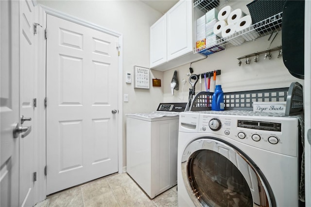 clothes washing area featuring cabinet space and washer and dryer