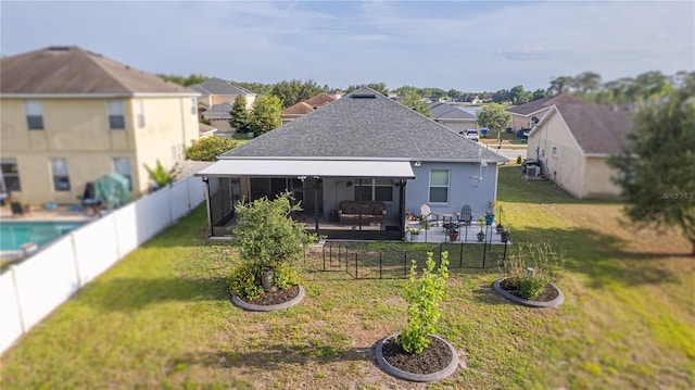 rear view of house with roof with shingles, a patio, a yard, and a residential view