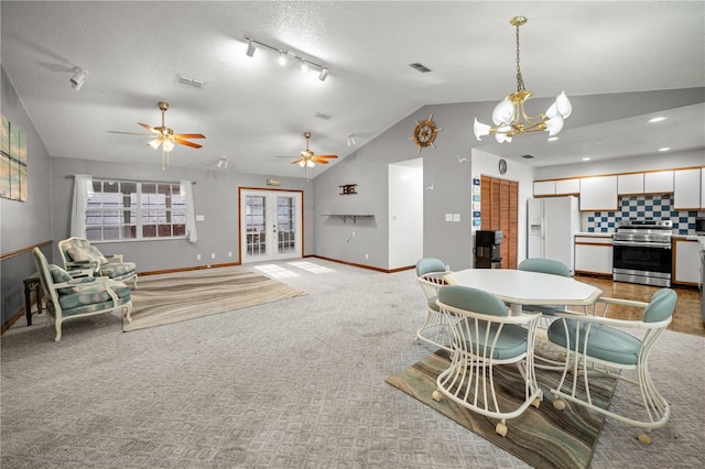 dining room with visible vents, vaulted ceiling, baseboards, and light colored carpet