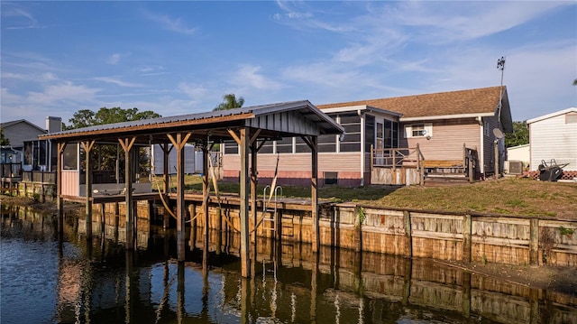view of dock with a lawn, boat lift, a water view, and central AC unit