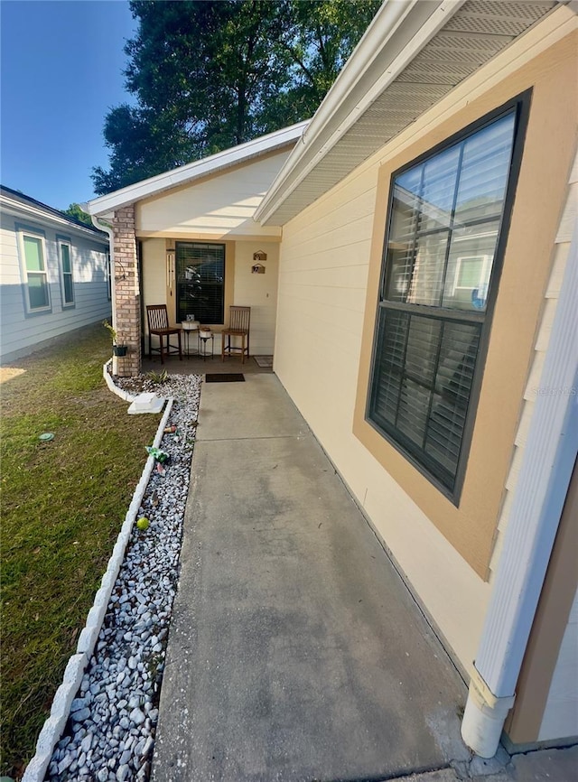 entrance to property with a porch and a lawn