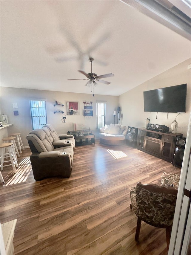 living area featuring a wealth of natural light, wood finished floors, and ceiling fan