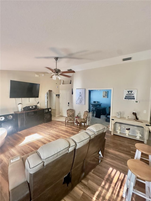 living room featuring ceiling fan, visible vents, and wood finished floors