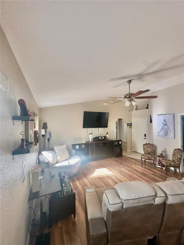 living room with wood finished floors, ceiling fan, and vaulted ceiling