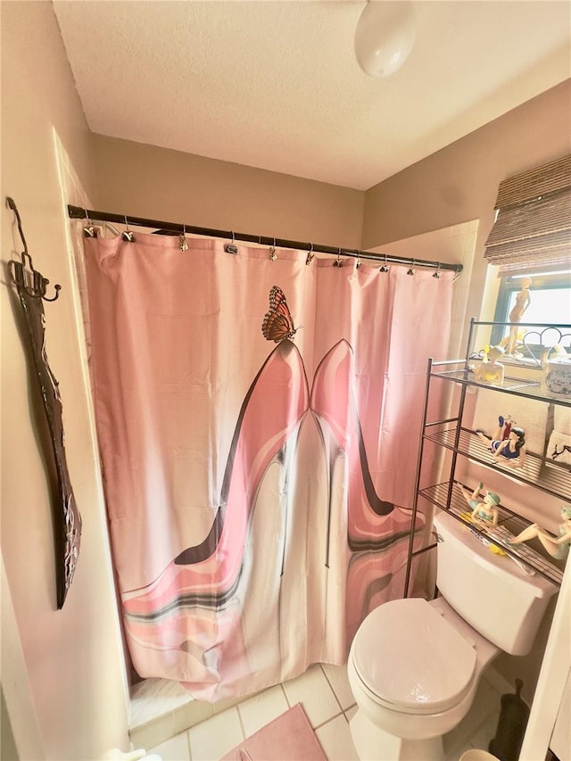 bathroom with toilet, curtained shower, tile patterned flooring, and a textured ceiling