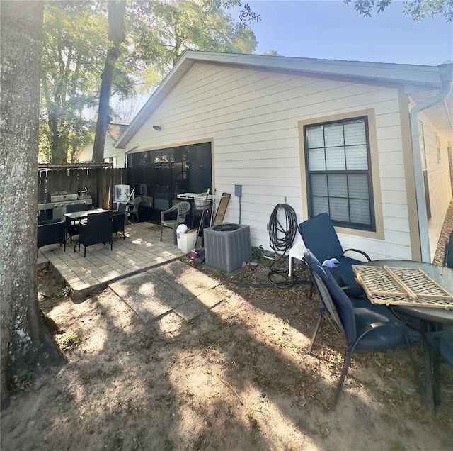 rear view of property with a patio, fence, and central AC