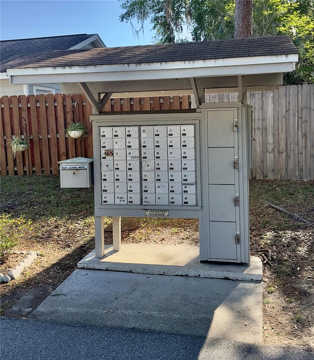 view of property's community with mail area and fence