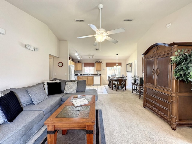 living room with lofted ceiling, visible vents, and light colored carpet
