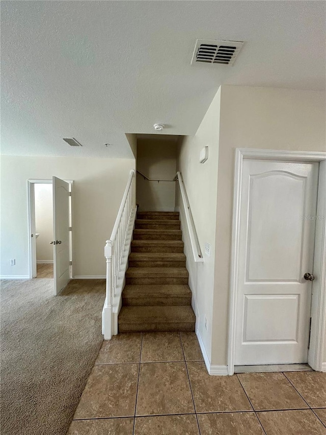2305 Chatham Place Dr, Orlando, FL 32824 - stairway featuring tile patterned flooring, baseboards, a textured ceiling, and carpet flooring