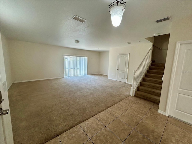 2305 Chatham Place Dr, Orlando, FL 32824 - carpeted empty room with tile patterned flooring, stairway, and baseboards