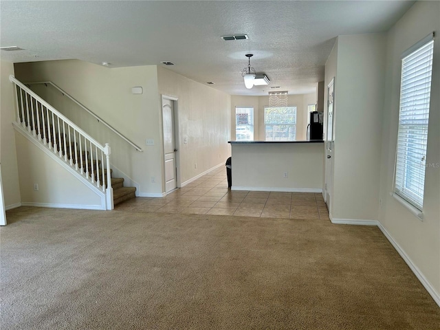 2305 Chatham Place Dr, Orlando, FL 32824 - unfurnished living room featuring carpet, a textured ceiling, baseboards, stairway, and tile patterned floors