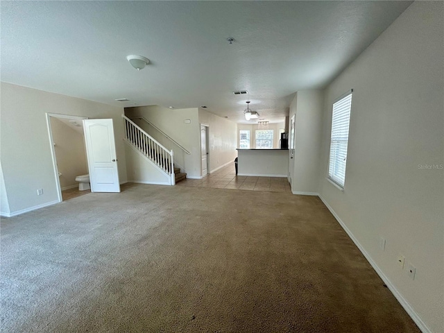 2305 Chatham Place Dr, Orlando, FL 32824 - unfurnished living room featuring light colored carpet, stairs, and baseboards