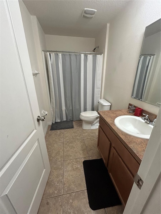 2305 Chatham Place Dr, Orlando, FL 32824 - full bathroom featuring vanity, toilet, tile patterned floors, a textured ceiling, and a shower with curtain