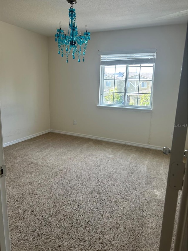 2305 Chatham Place Dr, Orlando, FL 32824 - carpeted spare room with baseboards, a textured ceiling, and a chandelier