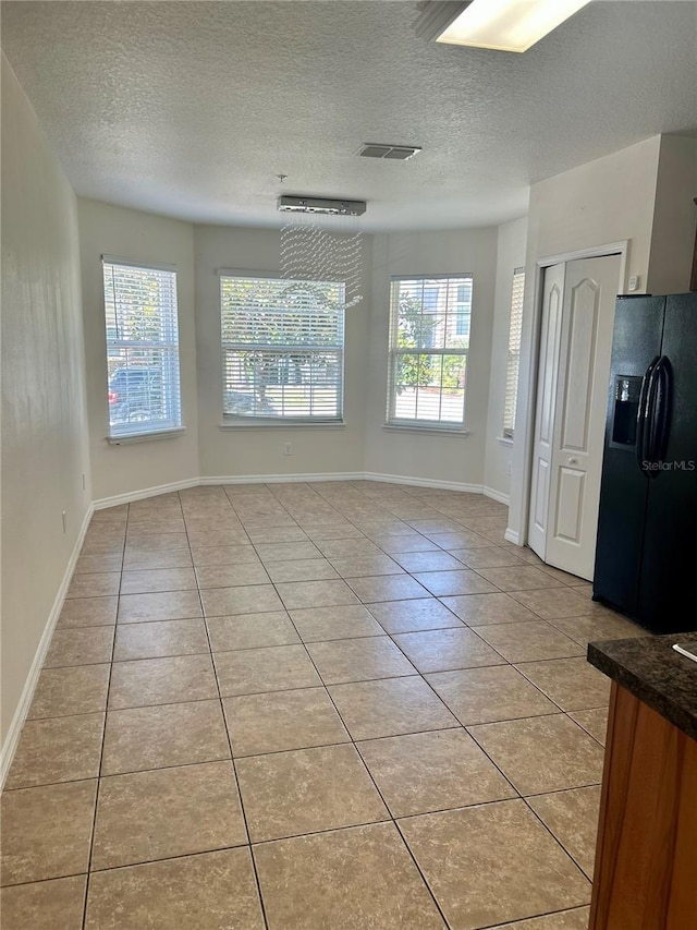 2305 Chatham Place Dr, Orlando, FL 32824 - spare room featuring light tile patterned floors, plenty of natural light, a textured ceiling, and baseboards