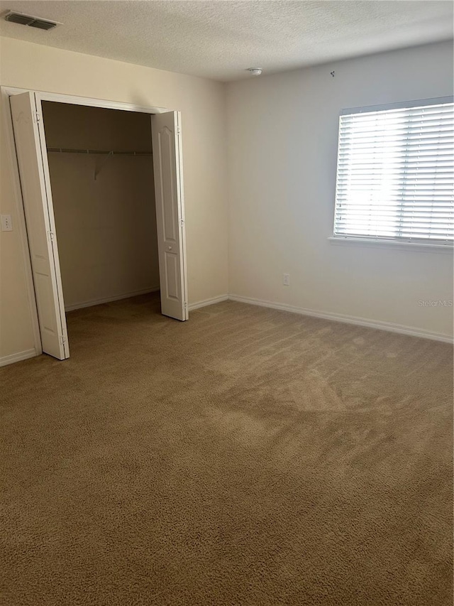 2305 Chatham Place Dr, Orlando, FL 32824 - unfurnished bedroom with carpet flooring, a textured ceiling, a closet, and baseboards