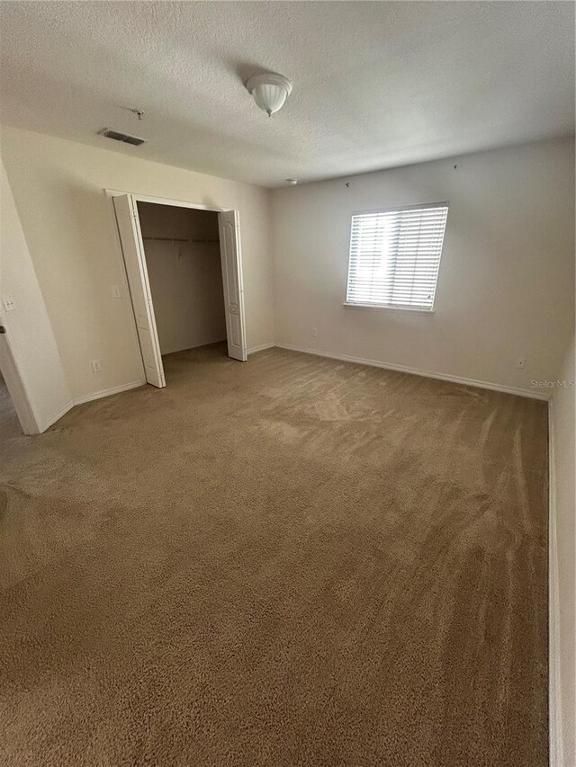 2305 Chatham Place Dr, Orlando, FL 32824 - unfurnished bedroom featuring light colored carpet, baseboards, a closet, and a textured ceiling
