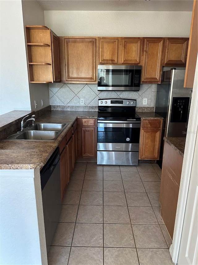 6141 Metrowest Blvd Unit 303, Orlando, FL 32835 - kitchen featuring appliances with stainless steel finishes, brown cabinetry, and backsplash