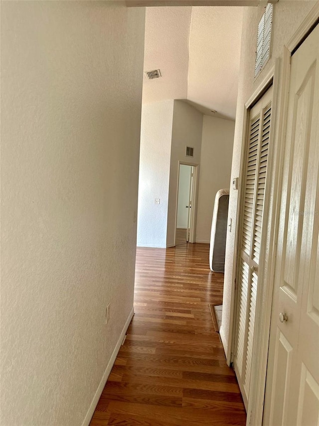 6141 Metrowest Blvd Unit 303, Orlando, FL 32835 - corridor featuring a textured wall, wood finished floors, vaulted ceiling, and a textured ceiling