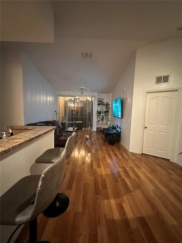 6141 Metrowest Blvd Unit 303, Orlando, FL 32835 - living room featuring vaulted ceiling, wood finished floors, and ceiling fan