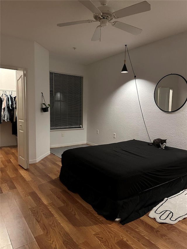 6141 Metrowest Blvd Unit 303, Orlando, FL 32835 - bedroom with wood finished floors, a walk in closet, and a ceiling fan