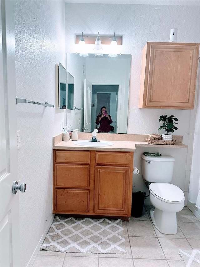 6141 Metrowest Blvd Unit 303, Orlando, FL 32835 - bathroom featuring vanity, tile patterned floors, and a textured wall