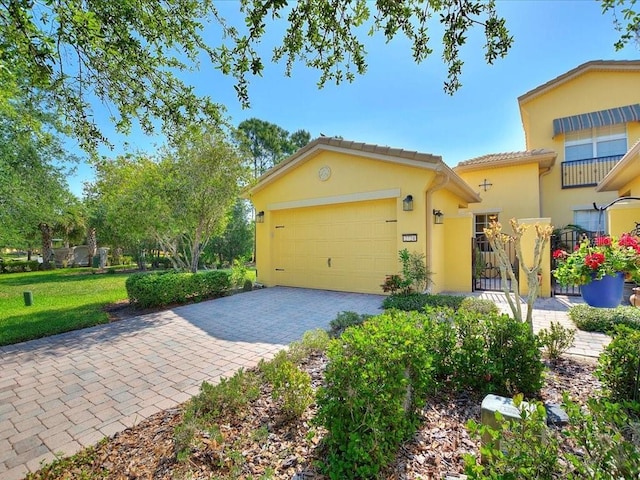 2724 Palm Tree Dr, Poinciana, FL 34759 - view of front facade with a tile roof, a front lawn, an attached garage, stucco siding, and decorative driveway