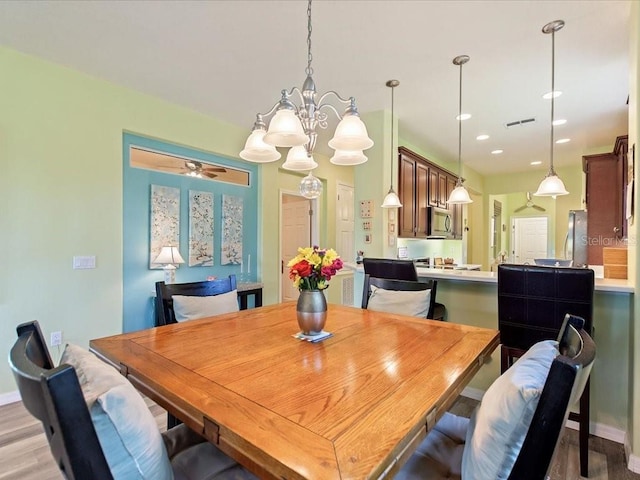 2724 Palm Tree Dr, Poinciana, FL 34759 - dining area featuring light wood finished floors, baseboards, visible vents, recessed lighting, and ceiling fan with notable chandelier