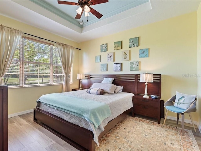 2724 Palm Tree Dr, Poinciana, FL 34759 - bedroom featuring baseboards, wood finished floors, a tray ceiling, and ornamental molding