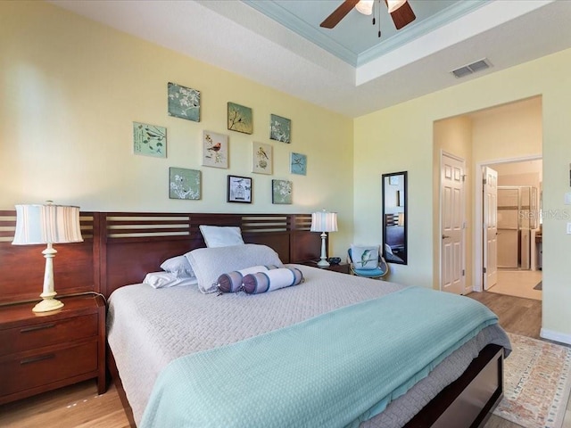 2724 Palm Tree Dr, Poinciana, FL 34759 - bedroom with a tray ceiling, visible vents, a ceiling fan, wood finished floors, and ornamental molding