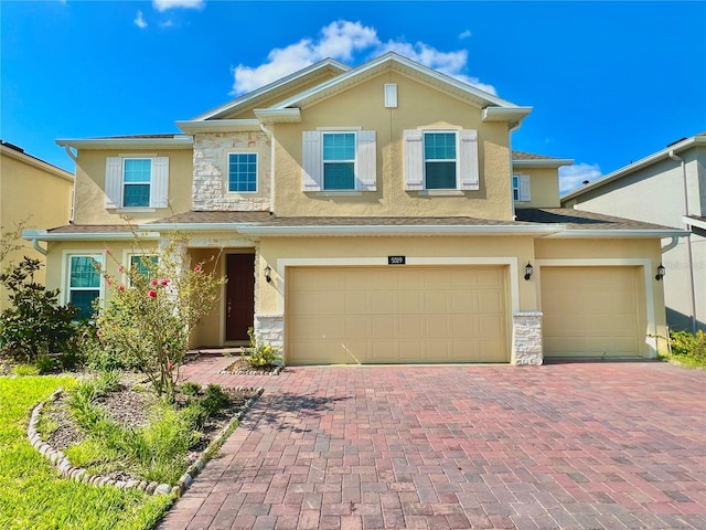5019 Down Ct, Saint Cloud, FL 34772 - view of front of home with an attached garage, stone siding, stucco siding, and decorative driveway