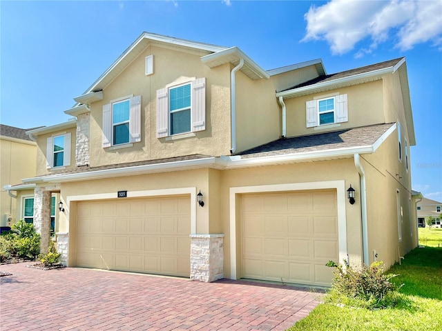 5019 Down Ct, Saint Cloud, FL 34772 - multi unit property with stucco siding, an attached garage, decorative driveway, and stone siding