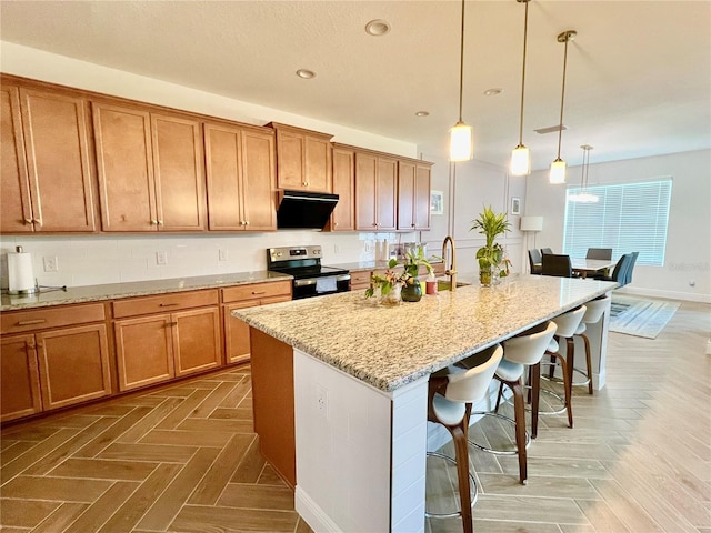 5019 Down Ct, Saint Cloud, FL 34772 - kitchen with an island with sink, extractor fan, light stone countertops, a kitchen bar, and electric range