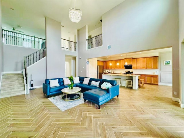 5019 Down Ct, Saint Cloud, FL 34772 - living room featuring a towering ceiling, visible vents, baseboards, a chandelier, and stairs