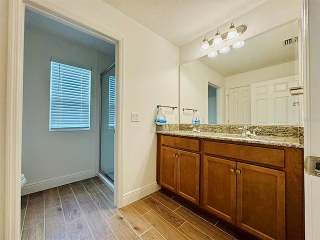 5019 Down Ct, Saint Cloud, FL 34772 - bathroom featuring wood tiled floor, double vanity, visible vents, a sink, and a stall shower